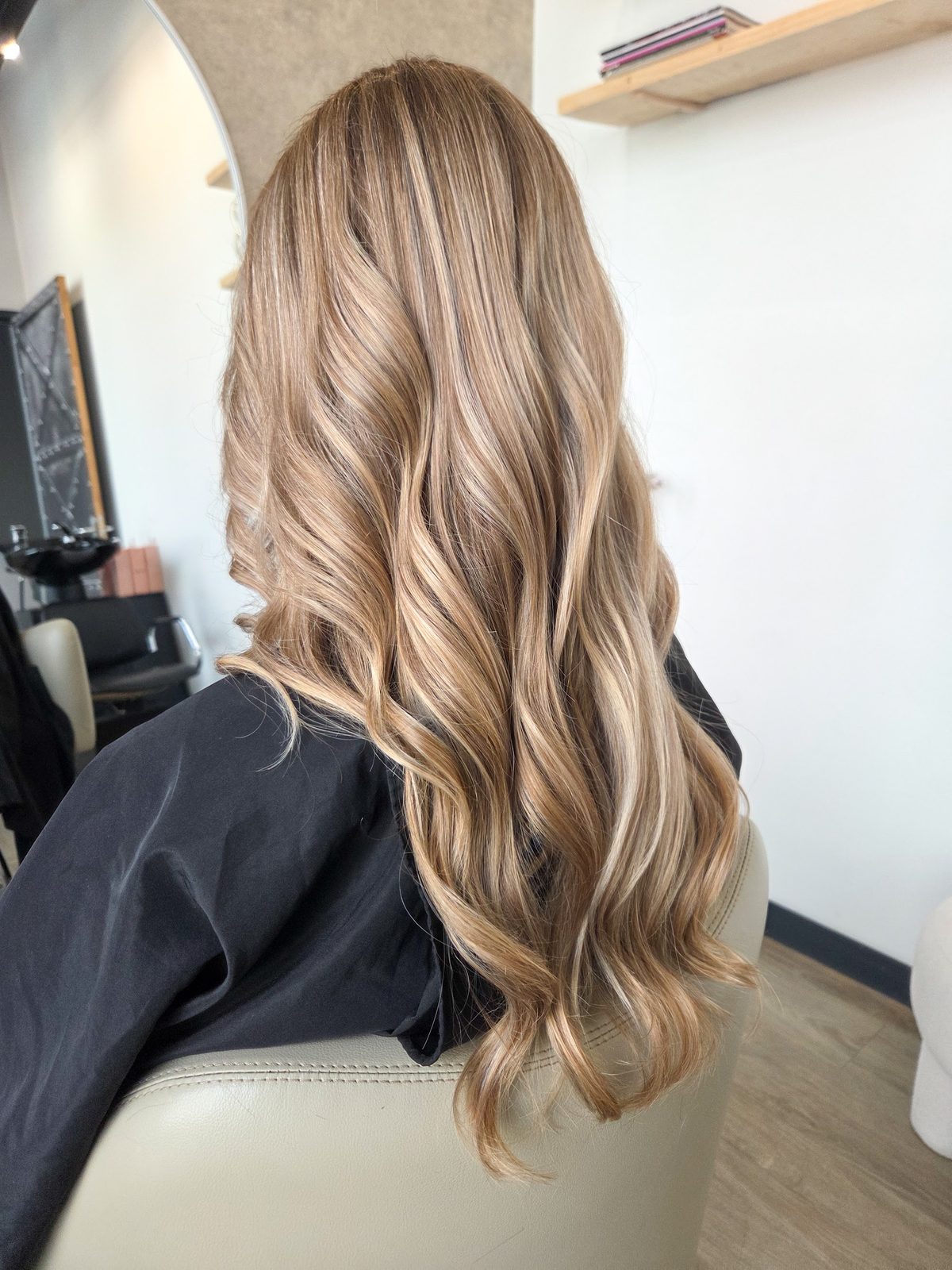 Lange goudblonde golven van een klant in de salon