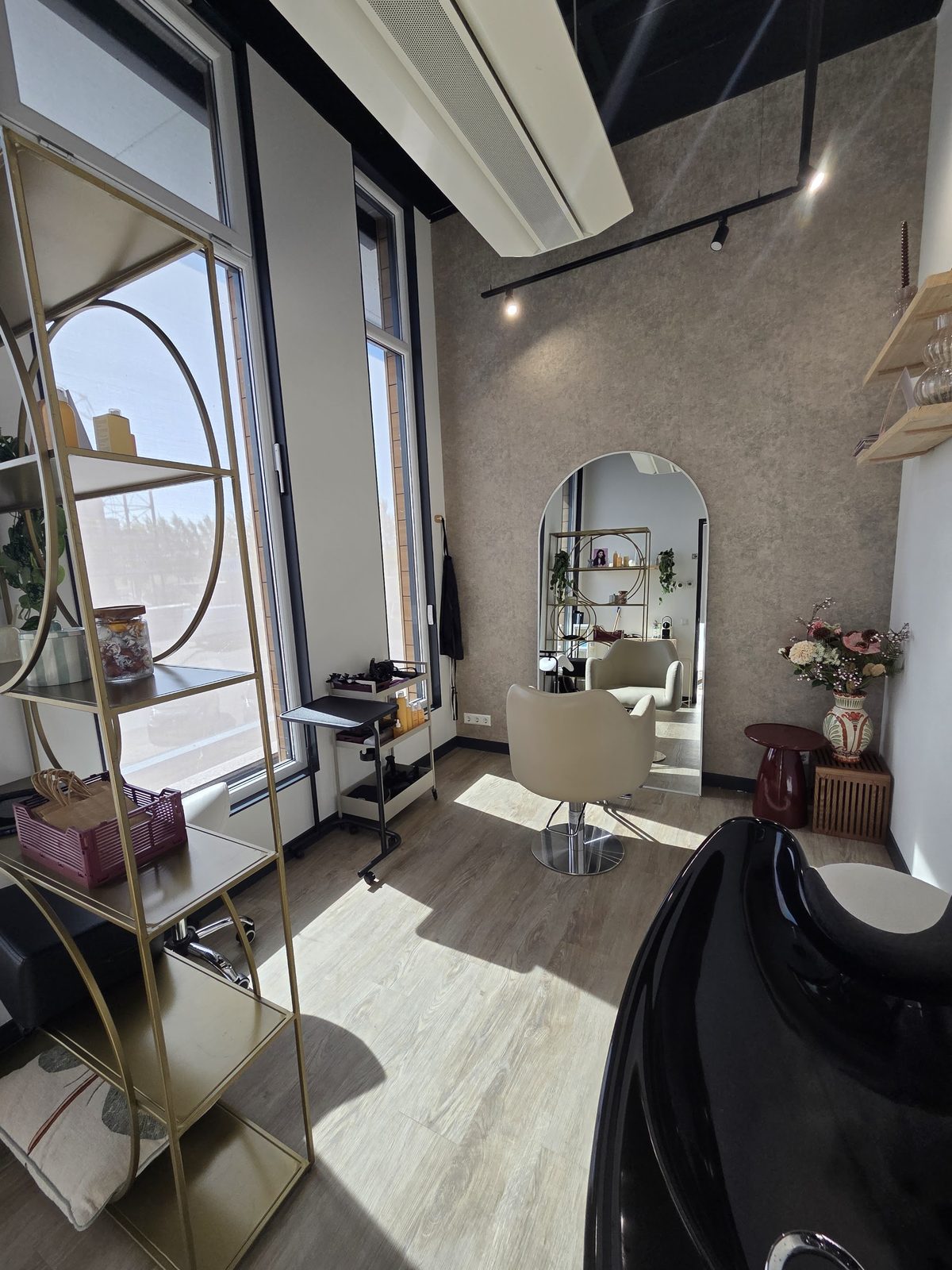 De salon met de gouden kast bij het raam, de wasbak en de gebogen spiegel